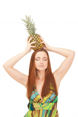 Girl with pineapple is pretending it is a crown